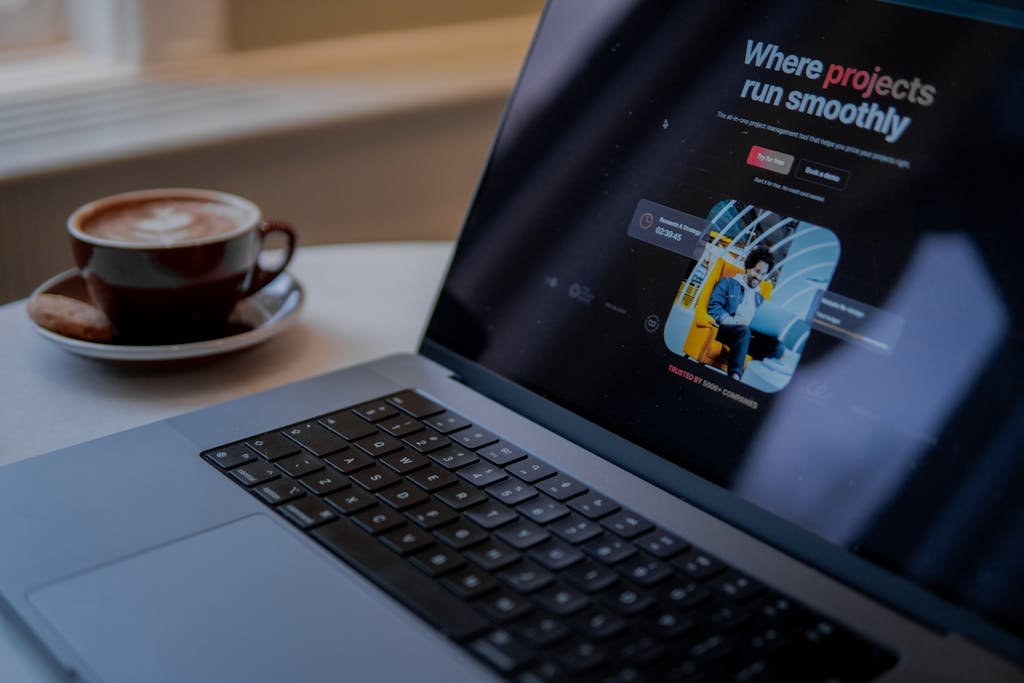 A laptop with a website on it and a cup of coffee